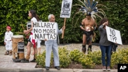 FILE - Los Angeles community members wait for Hillary Clinton's motorcade as they show their opposition to the Trans-Pacific Partnership in Beverly Hills, Calif., May 7, 2015.