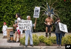 FILE - Los Angeles community members wait for Hillary Clinton's motorcade as they show their opposition to the Trans-Pacific Partnership in Beverly Hills, California, May 7, 2015.