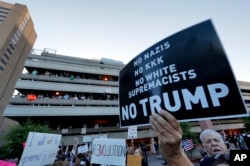 FILE - People protest outside the Phoenix Convention Center, Aug. 22, 2017, in Phoenix. Protests were held against President Donald Trump as he hosted a rally inside the convention center.