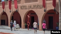 Tourists walk past Hotel California in the town of Todos Santos, Baja California Sur, Mexico, May 2, 2017. 