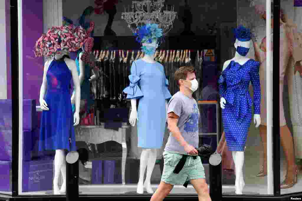 A man walks past a window display of a couture shop called Nataliya in Ascot, Britain, as racing resumes behind closed doors amid the outbreak of the COVID-19.