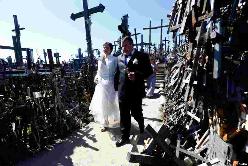 Newlyweds visit Hill of Crosses during Easter celebrations, near Siauliai in northern Lithuania. The origin of leaving the crosses on the hill is unknown.