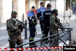 French police and soldiers secure a street near the Saint-Charles train station after French soldiers shot and killed a man who stabbed two women to death at the station, in Marseille, France, Oct. 1, 2017.