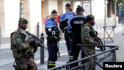 French police and soldiers secure a street near the Saint-Charles train station after French soldiers shot and killed a man who stabbed two women to death at the station, in Marseille, France, Oct. 1, 2017.