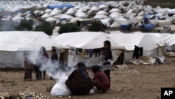 Phụ nữ Syria nhóm lửa bên cạnh lều của họ tại một trại tị nạn ở làng Atmeh, Syria, 11/12/2012
