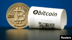 FILE - A Bitcoin (virtual currency) paper wallet with QR codes and a coin are seen in an illustration picture taken at La Maison du Bitcoin in Paris, France, May 27, 2015.
