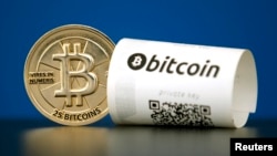 FILE - A bitcoin (virtual currency) paper wallet with QR codes and a coin are seen in an illustration picture taken at La Maison du Bitcoin in Paris, May 27, 2015.