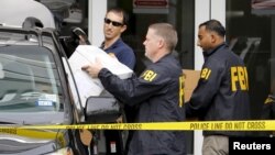 Les agents du FBI emportent des documents et autres objets lors d’une perquisition des bureaux d’Imagina à Miami, Floride, 3 décembre 2015