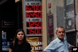 People stand outside an exchange office in Istiklal Avenue, the main shopping road in Istanbul, Sept. 13, 2018.