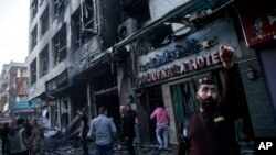 Personas revisan el área donde estalló un coche bomba en Qamishli, en el norte de Siria, el lunes 11 de noviembre de 2019. AP/Baderhgan Ahmad.