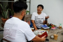 Ika Vantianti berbincang dengan rekannya Yolando Zelkeos Siahaya di sebuah kafe di Jakarta, 4 Maret 2021. (Foto: REUTERS/Willy Kurniawan