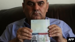 Fuad Sharef Suleman shows his US immigrant visa in Arbil, the capital of the Kurdish autonomous region in northern Iraq, Jan. 30, 2017, after returning to Iraq from Egypt, where him and his family were prevented from boarding a plane to the U.S. following President Donald Trump's decision to temporarily bar travelers from seven countries, including Iraq.