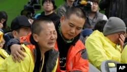 한국 진도항에서 열린 세월호 침몰 사고 1주년 전야 추모식에서 희생된 학생의 유가족이 오열하고 있다. 