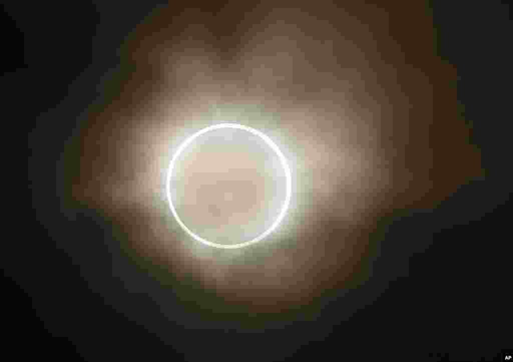 The moon slides across the sun, showing a blazing halo of light, during an annular eclipse at a waterfront park in Yokohama, Japan, May 21, 2012.