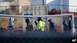 FILE - Teen migrants walk in line inside the Tornillo detention camp in Tornillo, Texas, Dec. 13, 2018.