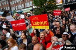 Supporters watch Jeremy Corbyn the leader of Britain's opposition Labour Party, as he speaks at an election campaign event in Harrow, June 7, 2017.