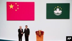 Macao Chief Executive Ho Iat Seng, left, poses with Chinese leader Xi Jinping for a photo after taking his oath at the inauguration ceremony in Macao, Dec. 20, 2019.