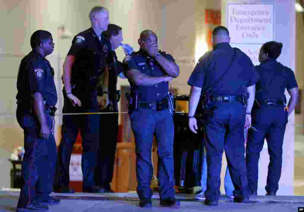 Un officier de police de Dallas pris d&rsquo;émotion, couvre son visage avec une main, en compagnie de ses collègues à l&rsquo;extérieur de la salle d&#39;urgence du centre médical de l&rsquo;université de Baylor, à Dallas, 8 juillet 2016. (AP Photo / Tony Gutierrez)