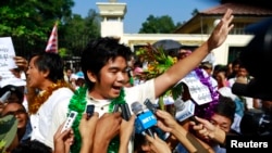 Political prisoners Yan Naing Tun (C) and Aung Min Naing (back L) talk to the media after being released from Insein prison in Rangoon, Dec. 31, 2013.