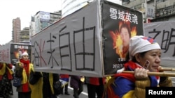 Activists carrying mock-ups of coffins to mourn for those who killed themselves in self-immolation, take part in a rally to commemorate the uprising in Lhasa 53 years ago against Chinese rule, March 10, 2012. 