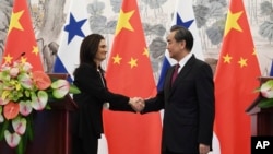 Panama's Foreign Minister Isabel de Saint Malo, left, shakes hands with her Chinese counterpart Wang Yi during a joint press briefing after signing a joint communique on establishing diplomatic relations, in Beijing, June 13, 2017.