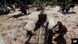 Cambodian workers use horse drawn carts for carrying sand to be used for construction through village of Samor Kroam, in Takeo province southwest of Phnom Penh, Cambodia, Tuesday, Dec. 9, 2014. (AP Photo/Heng Sinith)