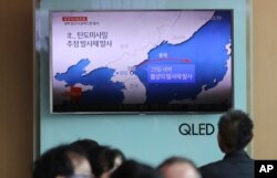 People sit in front of the TV screen showing a news program reporting about North Korea's missile firing, at Seoul Train Station in Seoul, South Korea, May 29, 2017.