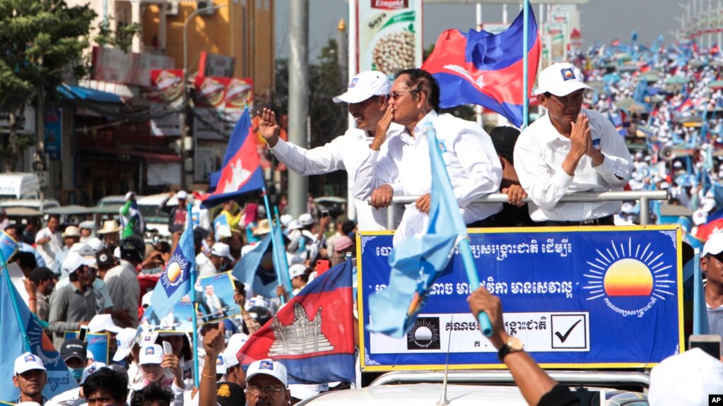 Opposition party Cambodia National Rescue Party (CNRP) President Kem Sokha greets his supporters from a truck as he leads a rally during the last day of campaigning ahead of communal elections in Phnom Penh, Cambodia, Friday, June 2, 2017. (AP Photo/Heng Sinith)