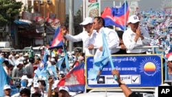 Opposition party Cambodia National Rescue Party (CNRP) President Kem Sokha greets his supporters from a truck as he leads a rally during the last day of campaigning ahead of communal elections in Phnom Penh, Cambodia, Friday, June 2, 2017. (AP Photo/Heng Sinith)