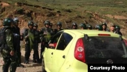 Chinese security forces block Tibetans from ascending hill to mark the Dalai Lama’s birthday on July 6, 2013.