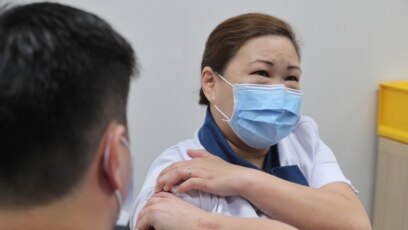 Vaksin virus corona COVID-19 diberikan kepada perawat staf senior Sarah Lim (kanan) saat Singapura memulai latihan vaksinasi. (Foto: AFP)