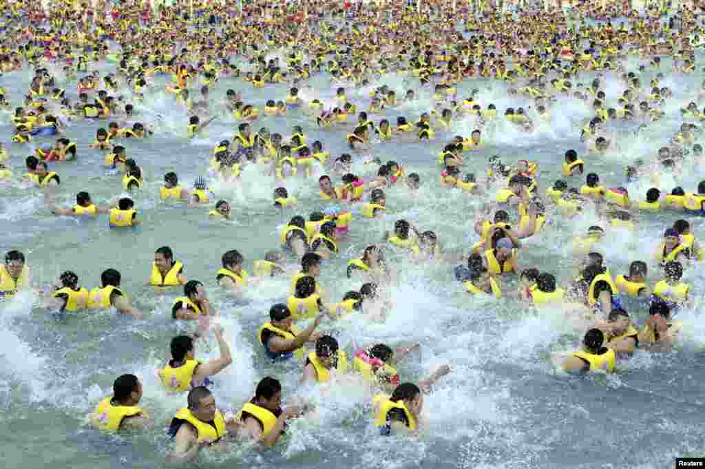People cool off in the summer heat at a water park in Xi&#39;an, Shaanxi province, China, July 8, 2014.