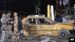 Security forces inspect the scene of a bomb attack in Basra, 550 kilometers southeast of Baghdad, Iraq, Thursday, Nov. 24, 2011.