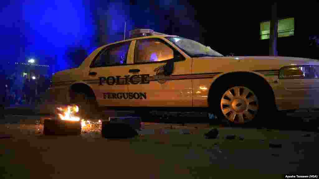 Sebuah mobil polisi dibakar massa di luar Balai Kota Ferguson, Missouri, 25 November 2014.