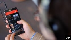 FILE - The YouTube Music app is displayed on a mobile phone, Nov. 13, 2015.