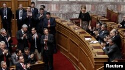 PM Yunani Antonis Samaras (kanan) dan para pembuat kebijakan pemerintah Yunani memberikan tepuk tanganseusai pelaksanaan putaran ketiga pemilu Presiden di Parlemen Yunani, Athena (23/12).