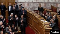 Greece's Prime Minister Antonis Samaras (R) and lawmakers of the government applaud after the second of three rounds of a presidential vote at the Greek parliament in Athens, Dec. 23, 2014. 