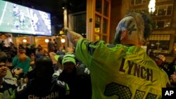 Stunned Seattle Seahawks fan Dustin Pittis points at a TV monitor, Feb. 1, 2015, as he watches the end of Super Bowl XLIX at a bar in Seattle, Washington.