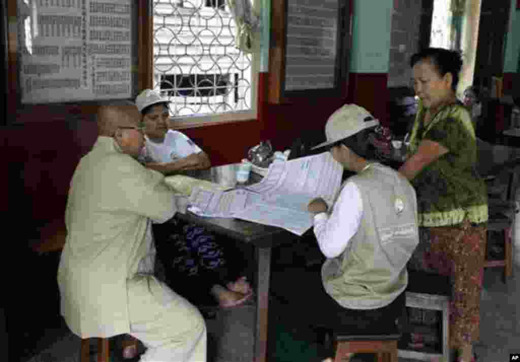 Myanmar census enumerators ask questions to a Chinese Buddhist nun as they collect information at a Chinese Buddhist temple Sunday, March 30, 2014, in Yangon, Myanmar. Enumerators fanned out across Myanmar on Sunday for a census that has been widely crit