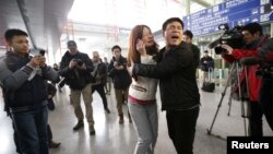 A relative of a passenger onboard Malaysia Airlines flight MH370 cries as she talks on her mobile phone at the Beijing Capital International Airport in Beijing, China, March 8, 2014. 