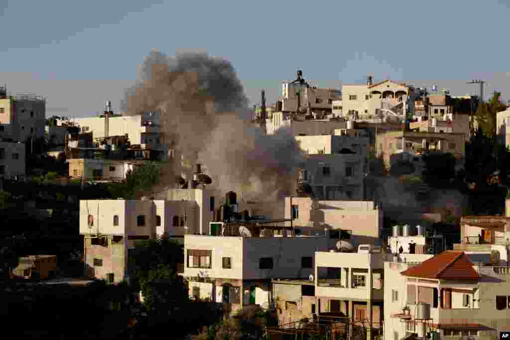 Smoke rises from the family home of Palestinian Ziad Awad in the town of Idna, west of the West Bank city of Hebron, July 2, 2014. Israel accuses Awad of having killed an Israeli police officer in April.