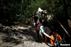 FILE - Migrants walk along a pathway after crossing illegally into Colombia across the Tachira river in Villa del Rosario, Colombia, Aug. 24, 2018.
