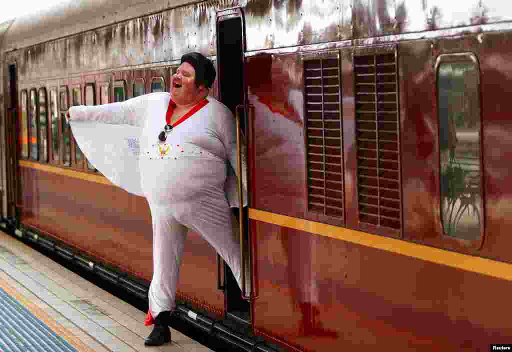 Elvis Presley impersonator Sean Wright poses next to the Elvis Express train at Sydney's Central station before it departs for the 26th annual Elvis Festival being held in the New South Wales town of Parkes in Australia.