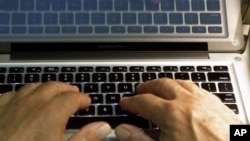 FILE - A photo illustration shows hands typing on a computer keyboard in Los Angeles. The Director of National Intelligence James Clapper warned Wednesday that cyberattacks will likely target presidential campaigns as they intensify.