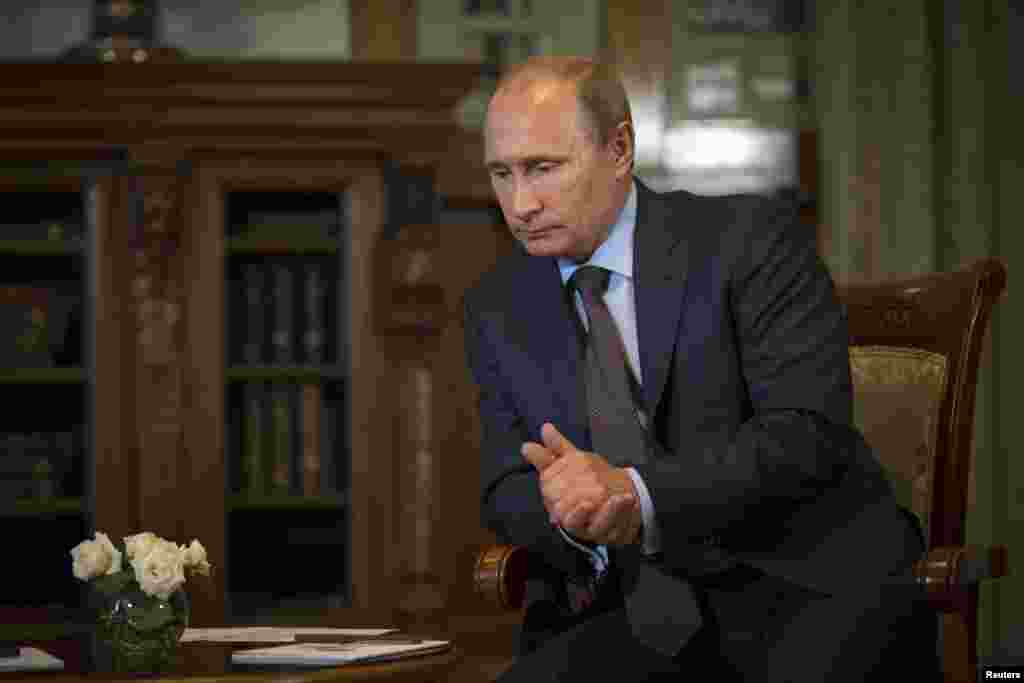 Russian President Vladimir Putin listens to French politician and businessman Philippe de Villiers. During their meeting, Putin said he believed many European leaders were eager to end the standoff over sanctions with Russia, at the Livadia Palace outside Yalta, Crimea, Aug. 14, 2014.