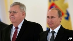 U.S. Ambassador to Russia John Tefft, left, and Russian President Vladimir Putin pose for a photo after presenting his credentials in the Kremlin in Moscow, Russia, Nov. 19, 2014. 