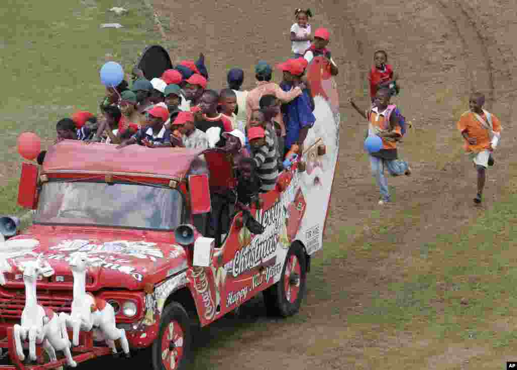 Les enfants suivent en courant un "Santamobile" (véhicule du père Noël) lors d'une fête de Noël pour les enfants défavorisés dans Maraisburg, Afrique du Sud, 7 décembre 2008.