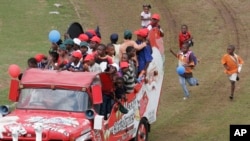 Des enfants suivent en courant un "Santamobile" (véhicule du père Noël) lors d'une fête de Noël pour les enfants défavorisés dans Maraisburg, Afrique du Sud, 7 décembre 2008.