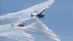 This handout photo taken and released by the Taiwan Defence Ministry on July 2, 2020 shows two US-made AH-64E attack helicopters releasing flares during a drill in Taichung. (Taiwan Defence Ministry/AFP)