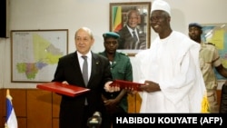 Le ministre de la Défense du Mali Bah N'Daw (à dr.) pose avec son homologue français Jean-Yves Le Drian le 16 juillet 2014 à Bamako après avoir signé un plan de coopération militaire. (Photo: HABIBOU KOUYATE/AFP)